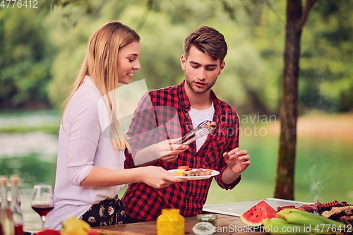 Image of friends having picnic french dinner party outdoor during summer holiday