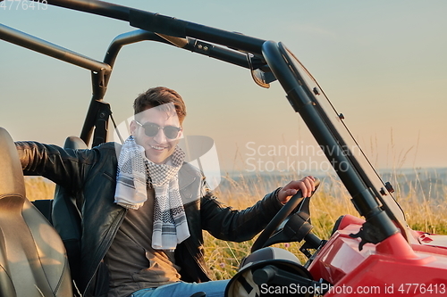 Image of man enjoying beautiful sunny day while driving a off road buggy car