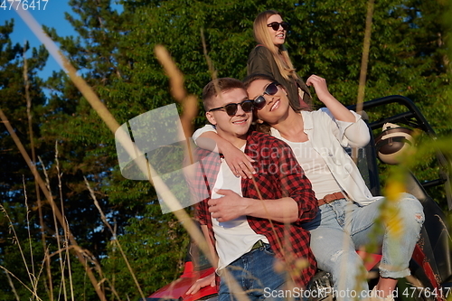 Image of group young happy people enjoying beautiful sunny day while driving a off road buggy car