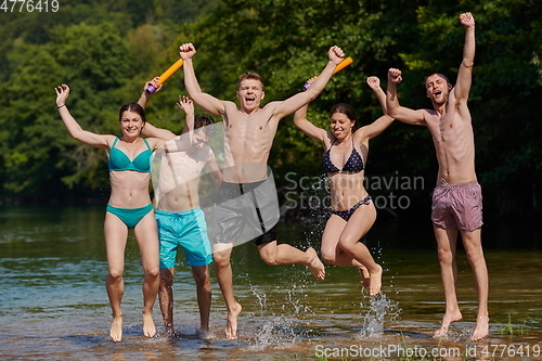 Image of group of happy friends having fun on river