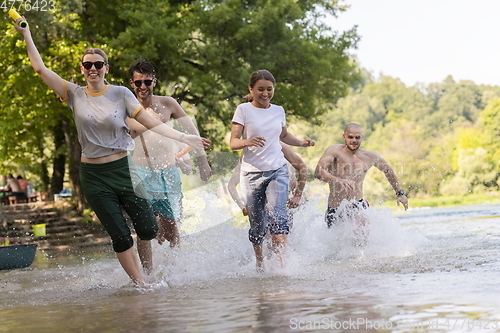 Image of group of happy friends having fun on river