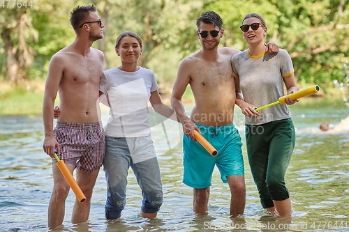 Image of group of happy friends having fun on river