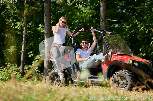 Image of couple enjoying beautiful sunny day while driving a off road buggy