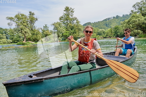 Image of friends are canoeing in a wild river