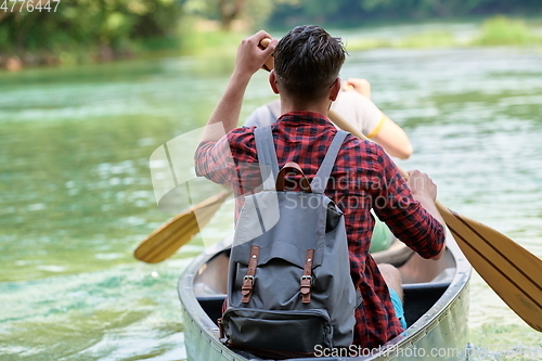Image of friends are canoeing in a wild river