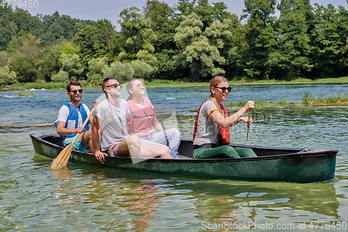 Image of Group adventurous explorer friends are canoeing in a wild river