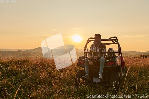 Image of man enjoying beautiful sunny day while driving a off road buggy car