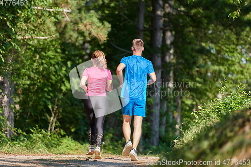 Image of couple enjoying in a healthy lifestyle while jogging on a country road