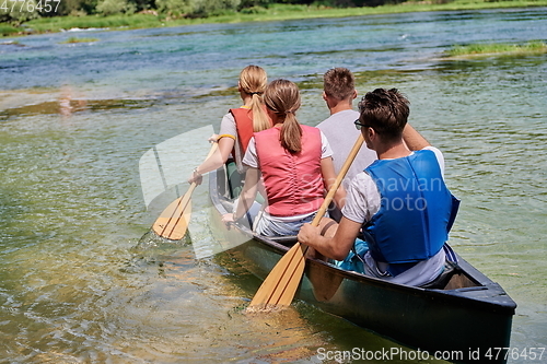 Image of Group adventurous explorer friends are canoeing in a wild river