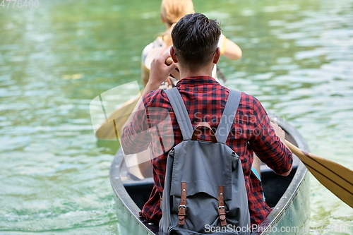 Image of friends are canoeing in a wild river