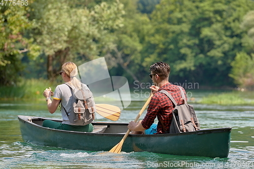 Image of friends are canoeing in a wild river