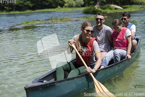 Image of Group adventurous explorer friends are canoeing in a wild river