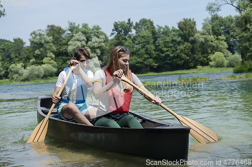 Image of friends are canoeing in a wild river