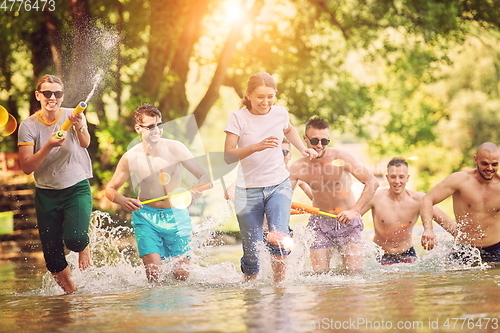 Image of group of happy friends having fun on river