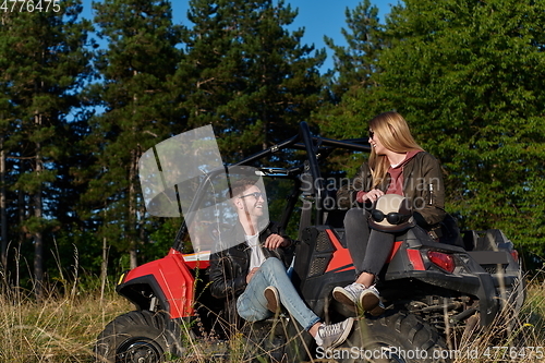 Image of couple enjoying beautiful sunny day while driving a off road buggy