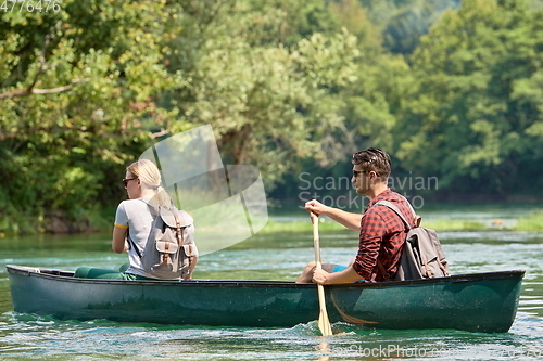 Image of friends are canoeing in a wild river