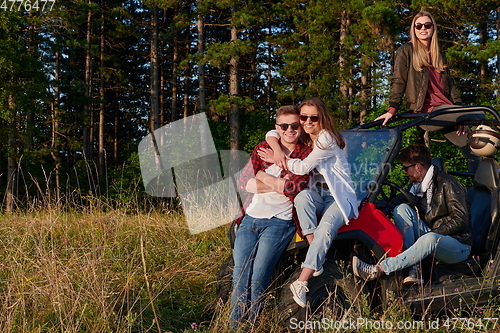 Image of group young happy people enjoying beautiful sunny day while driving a off road buggy car