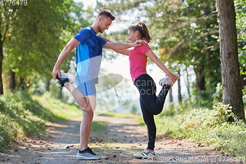 Image of couple enjoying in a healthy lifestyle warming up and stretching before jogging