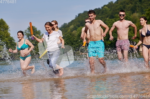 Image of group of happy friends having fun on river