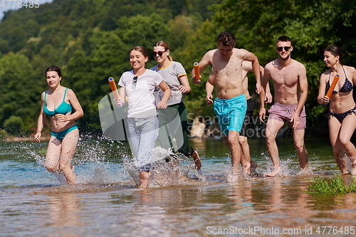 Image of group of happy friends having fun on river