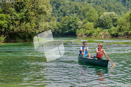 Image of friends are canoeing in a wild river