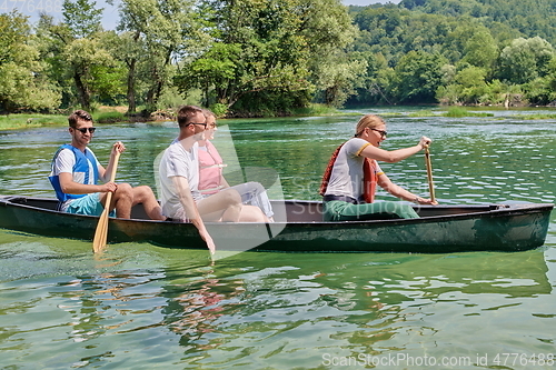 Image of Group adventurous explorer friends are canoeing in a wild river