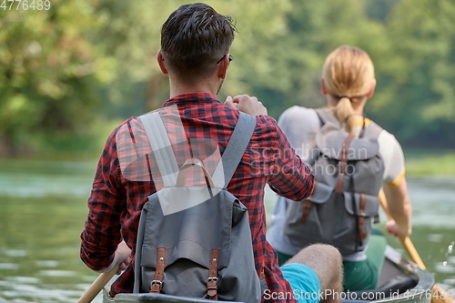 Image of friends are canoeing in a wild river