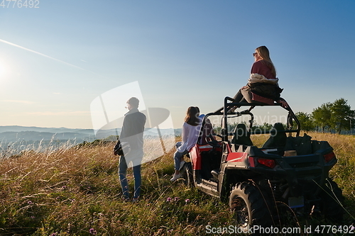 Image of group young happy people enjoying beautiful sunny day while driving a off road buggy car