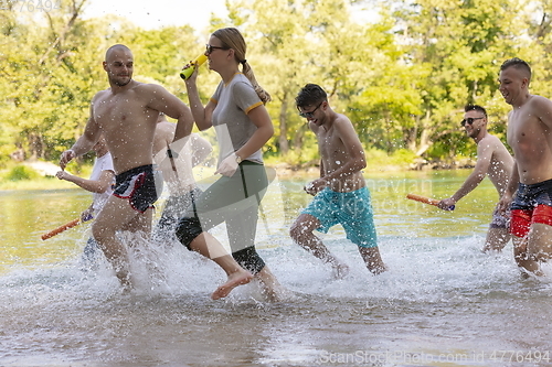 Image of group of happy friends having fun on river