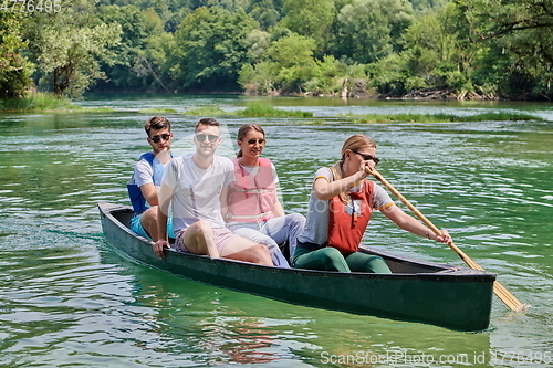 Image of Group adventurous explorer friends are canoeing in a wild river