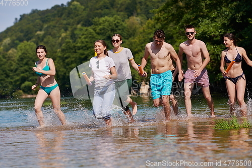 Image of group of happy friends having fun on river