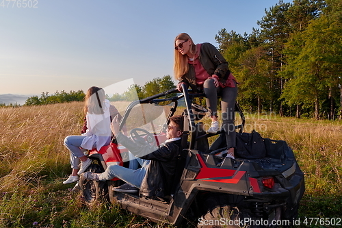 Image of group young happy people enjoying beautiful sunny day while driving a off road buggy car