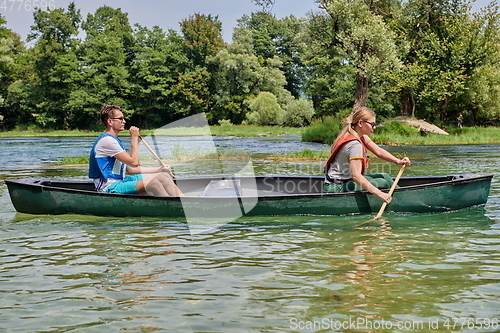 Image of friends are canoeing in a wild river