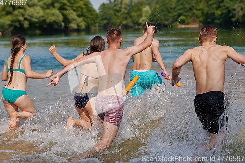 Image of group of happy friends having fun on river