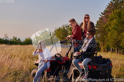 Image of group young happy people enjoying beautiful sunny day while driving a off road buggy car