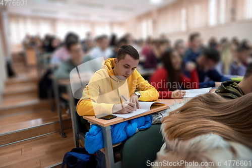 Image of student taking notes while studying in high school