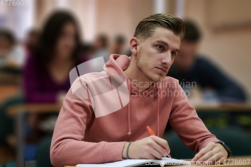 Image of student taking notes while studying in high school