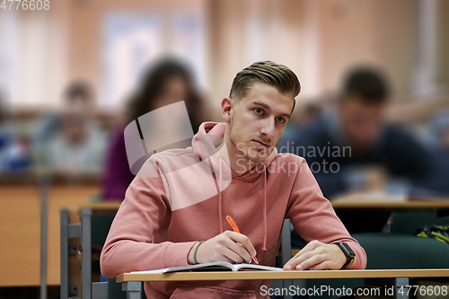 Image of student taking notes while studying in high school