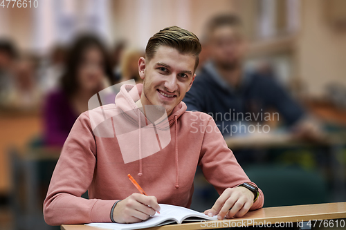 Image of student taking notes while studying in high school