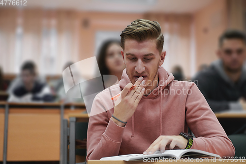 Image of student taking notes while studying in high school