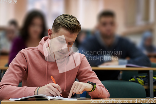 Image of student taking notes while studying in high school