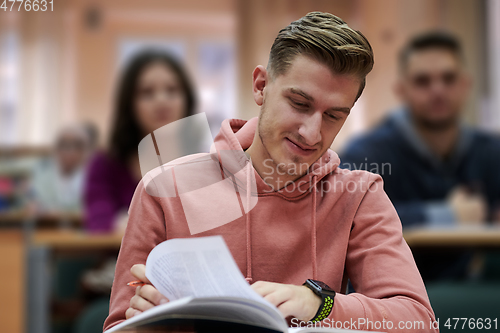 Image of student taking notes while studying in high school