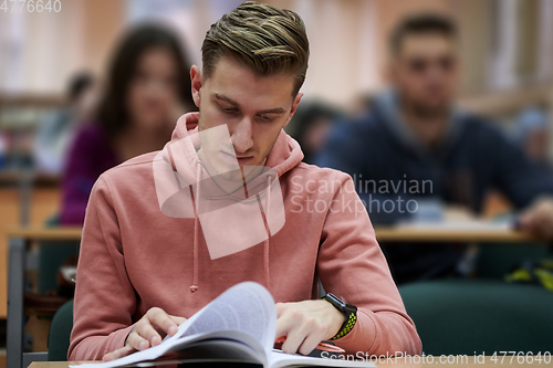 Image of student taking notes while studying in high school