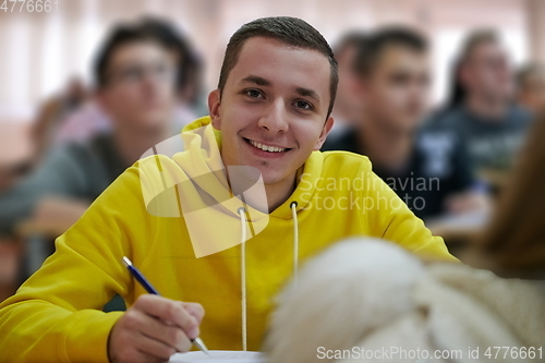 Image of student taking notes while studying in high school