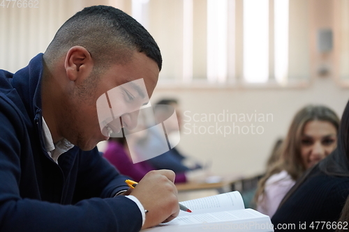 Image of student taking notes while studying in high school