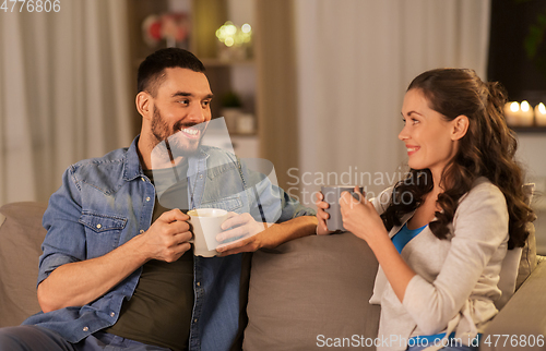 Image of happy couple drinking tea or coffee at home