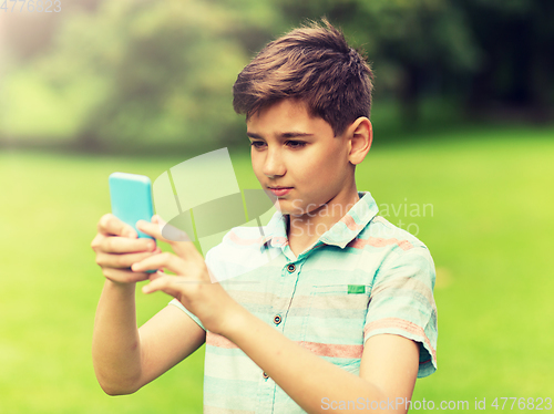 Image of boy with smartphone playing game in summer park