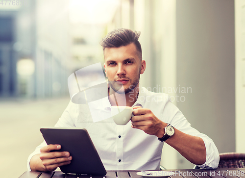 Image of man with tablet pc and coffee at city cafe