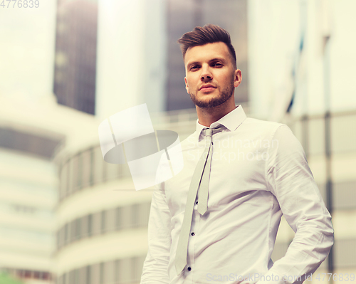 Image of young man in shirt and tie on city street