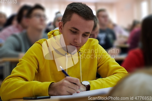 Image of student taking notes while studying in high school